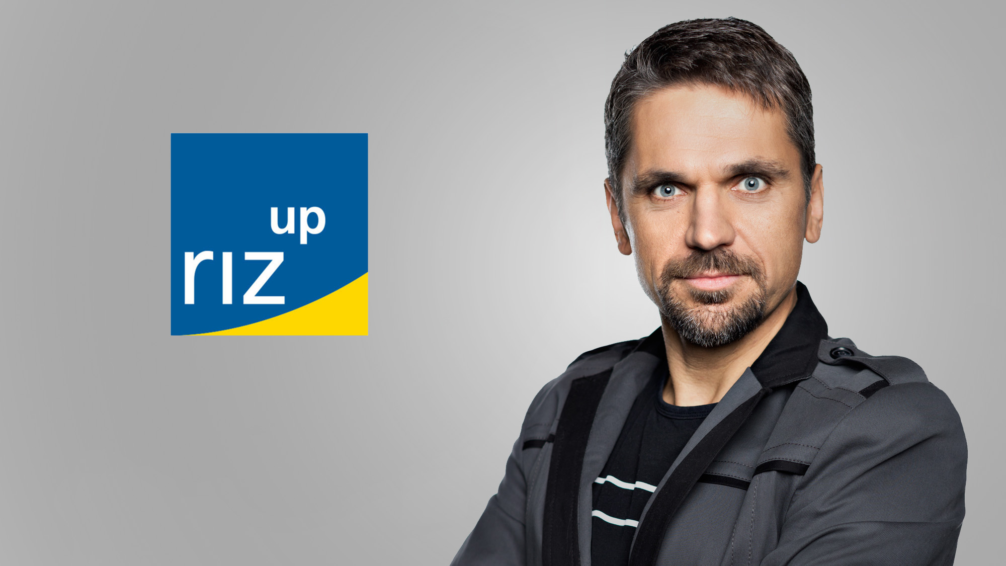 Foto von Michael Altrichter vor einfärbigen Hintergrund, neutraler Blick. Links davon das riz up Logo