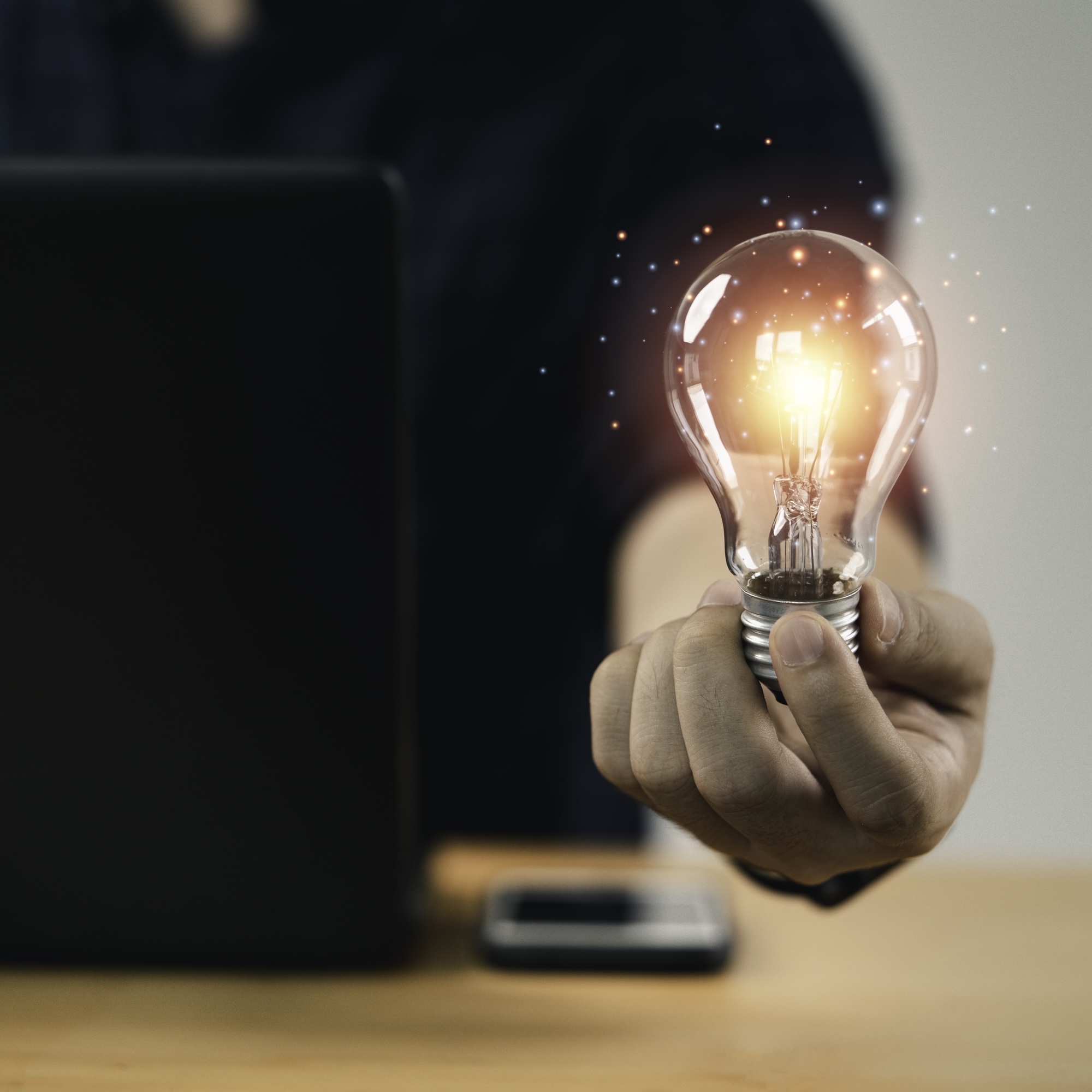 Businessman hand holding lightbulb with glowing light to creative smart thinking for inspiration and innovation with network concept.